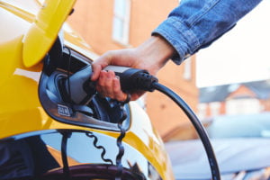 A man charging a zero emissions vehicle.