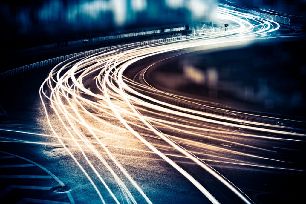 Light streaks of speeding cares on a road.